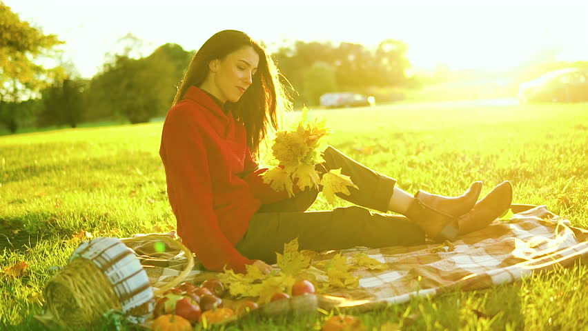 Beautiful woman walks on the grass on a sunny day