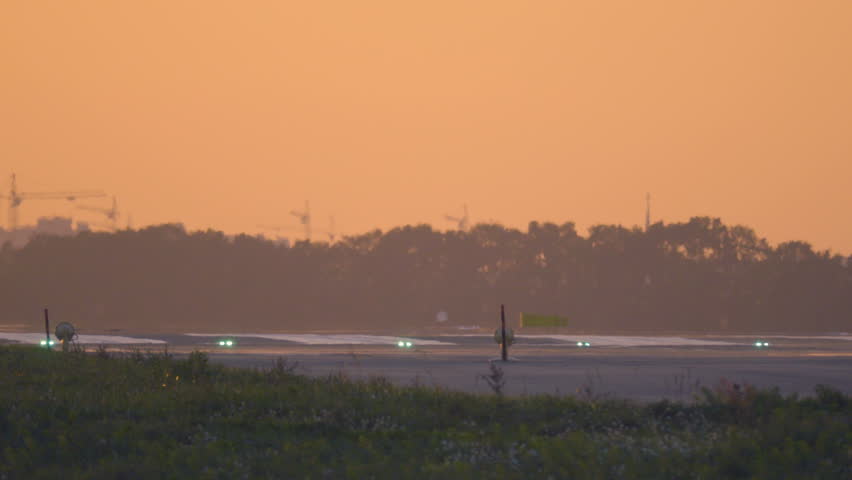 Airplane is landing to the runway at sunset. Back view Royalty-Free Stock Footage #1017457627