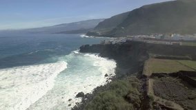 Above the coastline and a small village at Tenerife, Canary Island, Spain. 4K Aerial Footage.