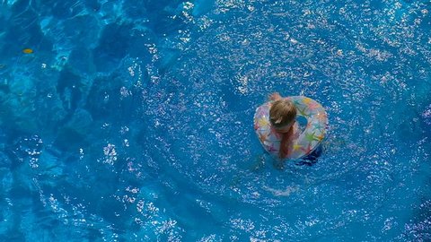 Boy floating on an inflatable circle in the pool, slow motion video
