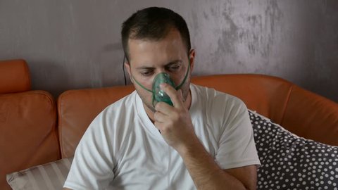 The portrait of a sick man makes inhalation, asthma hard breath.