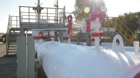 Oil pipeline in Russia. Video from stadikam with all the details. Transportation of oil. A pressure gauge. Sunny good weather. Blue sky. White pipes. Summer