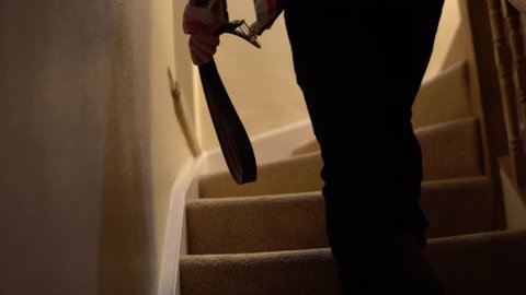 Domestic Child Abuse Concept With Father Walking Up Stairs With Belt.