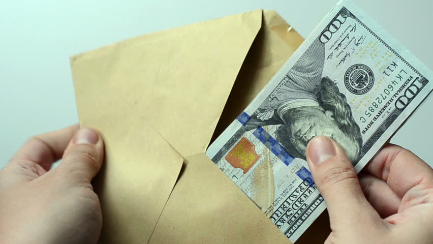 Person takes an envelope with 100 dollar banknotes. Counting hundred dollar banknotes in a hands. Illegal deal with money. Corruption. Envelope salary. Tax cheating.  | Shutterstock HD Video #1017474403