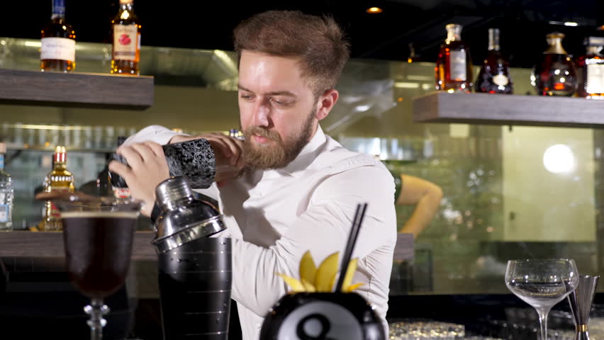 Bartender shaking a cocktail in shaker at his bar table Royalty-Free Stock Footage #1017479083