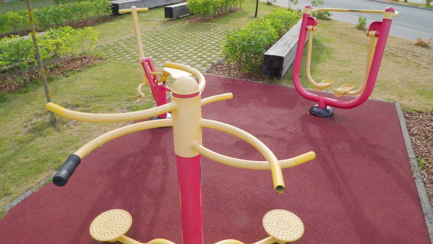 The playground area outside the lawn with the yellow and red rides on the park