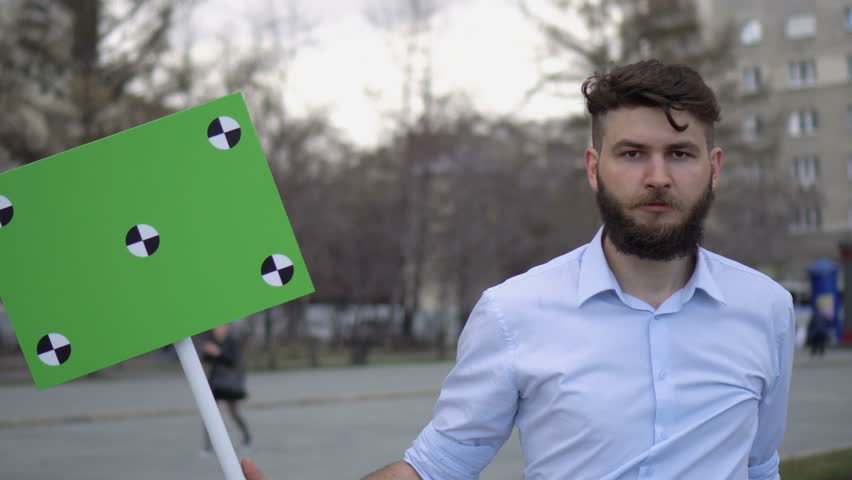People at the demonstration with banners in their hands look into camera and smile. Funny guys talk at a rally. Protesters are on the street in the city. A men agitates by propaganda with a poster 4k.