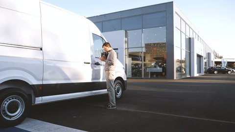 LYON, FRANCE - CIRCA 2018: customer taking decision to buy the white Volkswagen Crafter transporter van 3 to 5 tone van produced and sold by Volkswagen Commercial Vehicles calculating the price