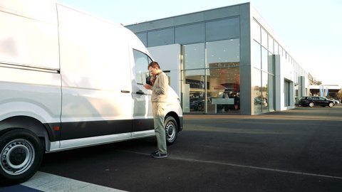 LYON, FRANCE - CIRCA 2018: Curious Caucasian young customer admiring the price and interior of the white Volkswagen Crafter transporter van time lapse fast motion