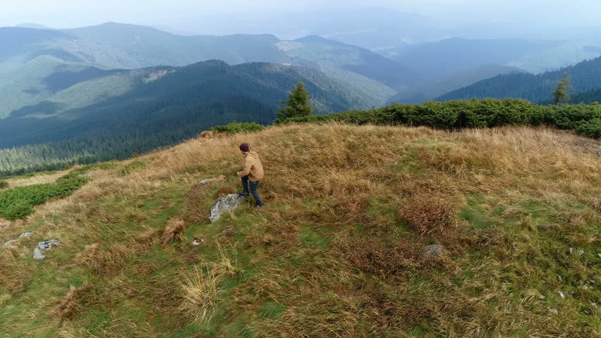 The male standing on the mountain on the beautiful landscape background