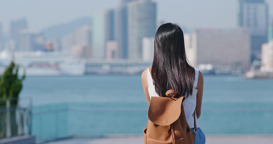 Woman look at the view of kowloon peninsula in Hong Kong