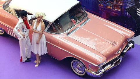SAINT-PETERSBURG / RUSSIA - SEPTEMBER 29 2018: Elvis Presley with Marilyn Monroe are posing near cadillac on retro car show