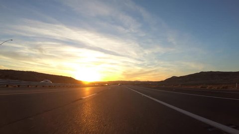 Driving into the sunset on Interstate 15 in the Mojave desert near Barstow, California. 