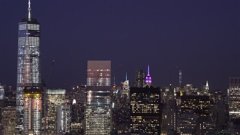 New York City Circa-2015, low flying telephoto aerial view of Lower Manhattan Financial District office buildings with the Midtown Skyline in the background at night