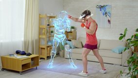 Muscular Caucasian man in VR headset boxing with holographic opponent while practicing punches in the living room - Powered by Shutterstock - Get 15% off with code: PIKWIZARD15