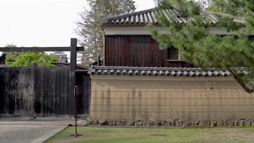 outside of the temple, wall built by wooden. translation on the sign text cars are not allowed to drive in"."