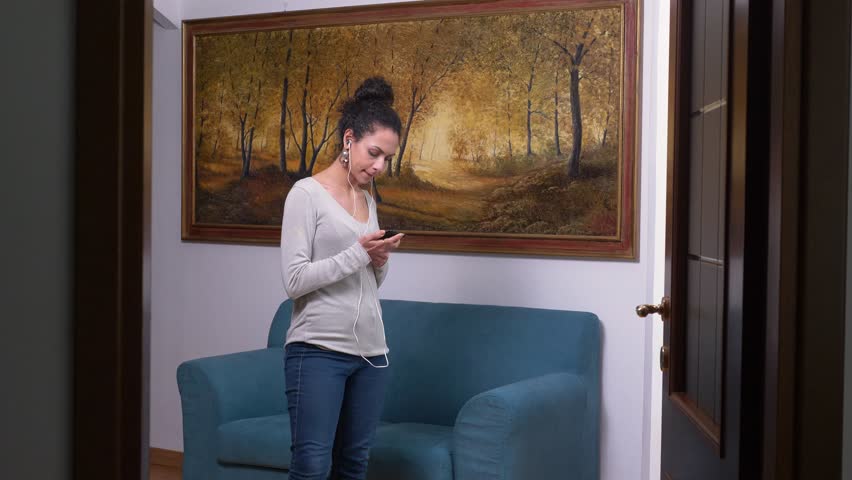 carelessness, joy, free time. Beautiful woman dances listening to music at home