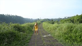 One young woman running happily in nature on rice field nature walk in Ubud, Bali. People travel fun happiness concept- Slow motion HD