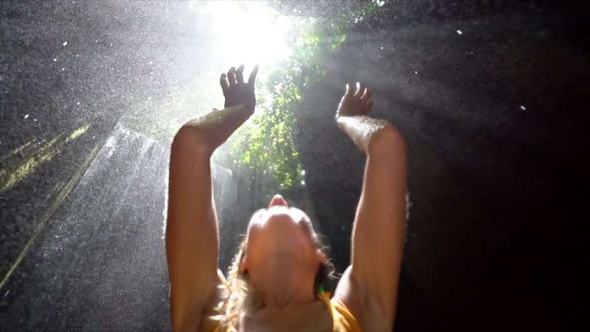 Young woman in tropical rainforest looking up at beautiful light and touching the rain drops with hands. People travel enjoying nature and life concept. Slow motion video | Shutterstock HD Video #1017532867