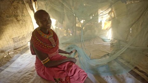 Mother and daughter using mosquito net, Kenya.