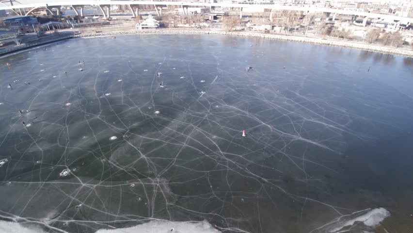 Drone Aerial shot of people ice fishing on a frozen lakeshore state park inlet lake.