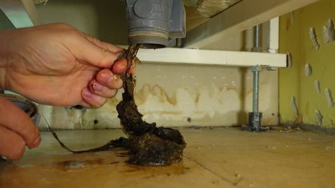 Fixing Problem with clogged plumbing. Unclogging pipe and drain, removing loses hair and other stuff. Home keeping  and Care for domestic appliances concept.