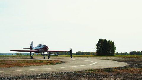 View of moving airplane on grassy airfield close up; classic plane taxiing to takeoff on runway; training aerobatic flight of oldschool aircraft; leisure activity and entertainment for visitors