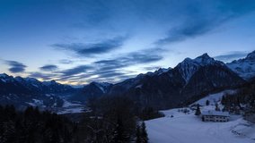 Beautiful 4k UHD timelapse video of the sun and clouds at sunrise in the Brandnertal in the mountains of the Alps in Vorarlberg, Austria, in winter with snow