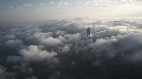 New York City, New York - Circa 2015: Aerial view of Lower Manhattan, covered by thick fog at sunrise, while the World Trade Center, Empire State Building and 432 Park Avenue poke through the clouds
