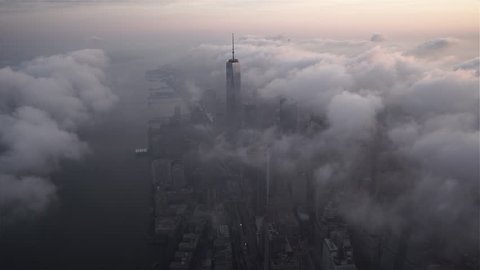 New York City, New York - Circa 2015: Aerial view approaching Lower Manhattan's Financial District and One World Trade Center, covered by fog and low level clouds at sunrise
