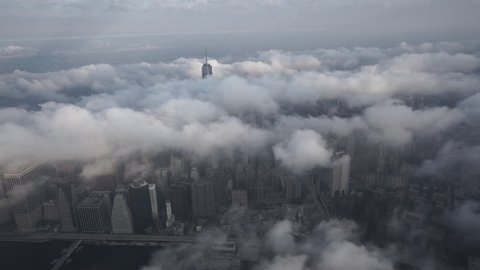 New York City, New York - Circa 2015: Aerial view of Lower Manhattan's Financial District, covered by low level clouds in the morning, from above the Brooklyn Bridge