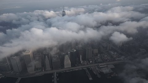 New York City, New York - Circa 2015: Aerial view of the east side of Lower Manhattan's Financial District from the East River, covered by low level clouds in the morning