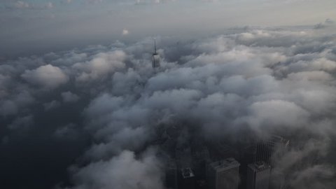 New York City, New York - Circa 2015: Aerial view of Lower Manhattan's Financial District from the East River, covered by low level clouds in the morning