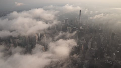 New York City Circa-2015, aerial view flying over Midtown Manhattan skyscrapers under fog and low level clouds at sunrise