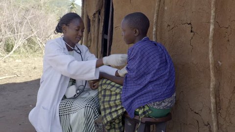 Nurse examining female patient. Maasai village. Kenya.