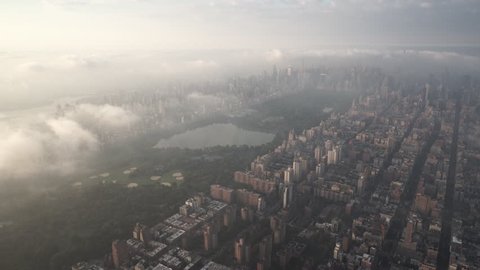 New York City Circa-2015, aerial view of Central Park from the Upper West Side, with the Upper East Side and Midtown Manhattan covered in fog and low level clouds at sunrise