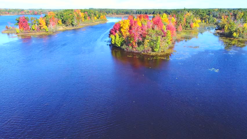 Autumn in Northern Wisconsin, colorful scenic treetop drone flyover of amazing forests and river.
