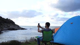 taking video by the sea with smart phone while camping