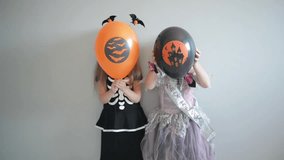 Couple Of Two Smiling Little Girls Dressed In Halloween Costumes Holding Air Balloons And Posing. - Powered by Shutterstock - Get 15% off with code: PIKWIZARD15