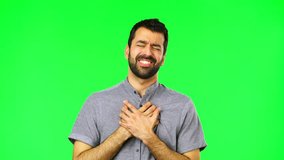 Handsome man on green screen chroma key with heart pain