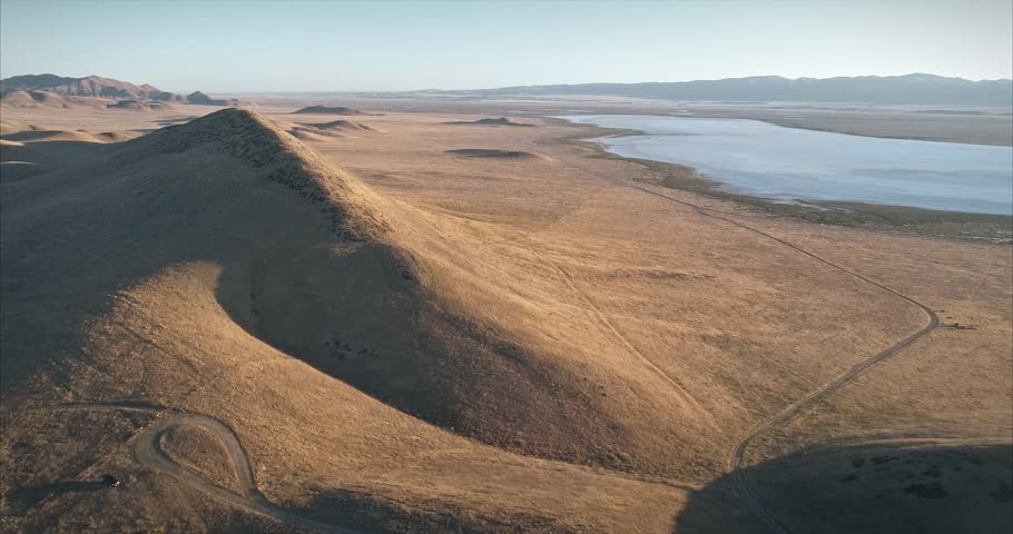 Aerial over grass and rolling hills of Carrizo Plain Monument at sunrise. The San Andreas fault runs through the park.
