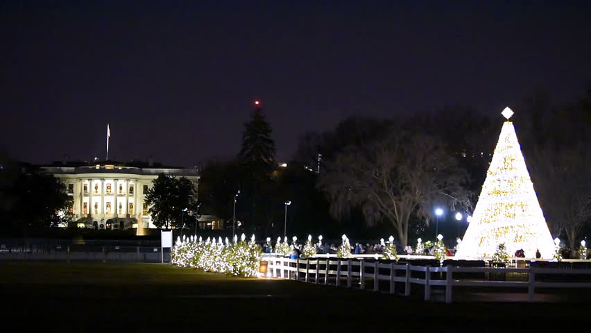 Washington DC, USA - December 28, 2018: White House with illuminated Christmas tree before New Year eve with ornament, illumination at dark hour night with many people walking by fence