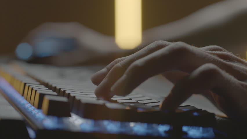 Video gamer or hacker. Hands on computer keyboard and mouse with RGB backlight. Close-up dolly panning. Shallow depth of field Royalty-Free Stock Footage #1017586447