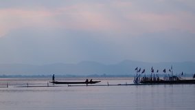 a boat man sails with passenger by old boat ferry in the lake on sunset - Powered by Shutterstock - Get 15% off with code: PIKWIZARD15