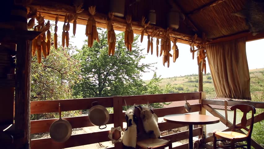 Rustic setting. A nice terrace with a table and dried corn hanging from the ceiling. 