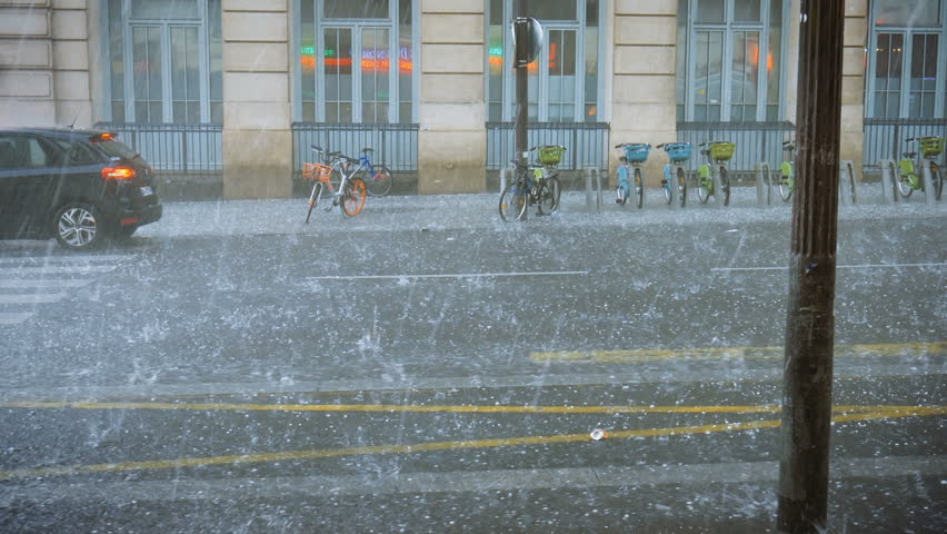 Extreme weather hail rain storm on the streets of Paris hail beats bicycles