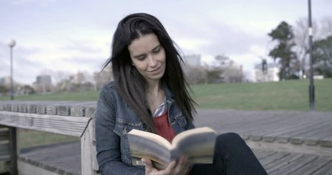 Beautiful woman reading outdoors – 4K