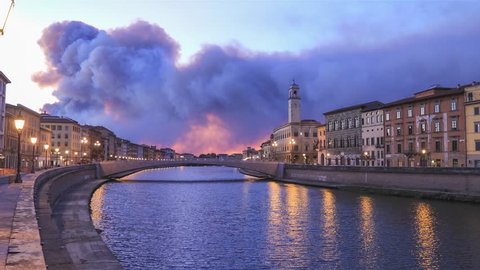 Ponte di Mezzo bridge over Arno river and Clock tower at dusk in Pisa, Italy
