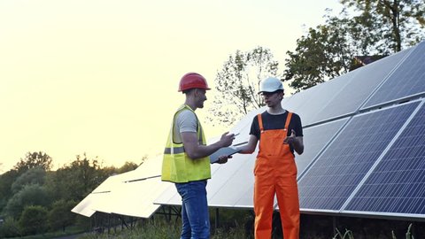 Two engineers working on checking and maintenance equipment in a solar power plant