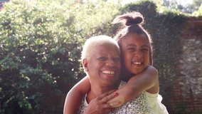 Senior black woman and granddaughter sit embracing outside - Powered by Shutterstock - Get 15% off with code: PIKWIZARD15